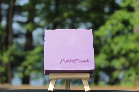 A handmade purple bar of soap that is  scented with Black Cherry Merlot and Champagne fragrances. Bueno Y Merlot was made from 100% organic oils.